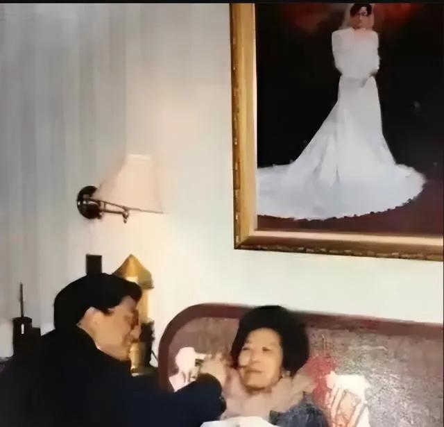 20世纪90年代，黄菊给夫人余慧文喂药的温情场景。可以看到床头挂着大幅的婚纱照。