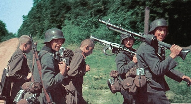 1941年夏天，行进中的德国步兵和两名携带弹药的苏联红军战俘。