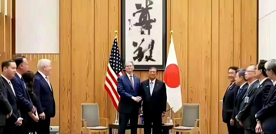 下面两张图是日本首相分别接见美中外长的背景图。墙上挂着的字是“尊敬”和“解衣”？