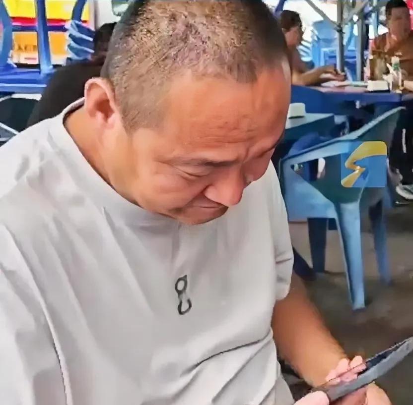 男子和家人正在大排档吃饭，这时儿子突然拿出一个小礼物递给了他，男子瞧了一眼是新手