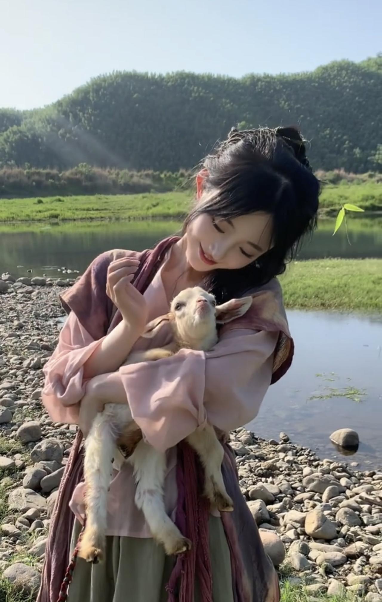 草原的女儿
河畔，她着轻衫，怀抱小羊
似一幅灵动的画，嵌入草原的时光
微风，梳理