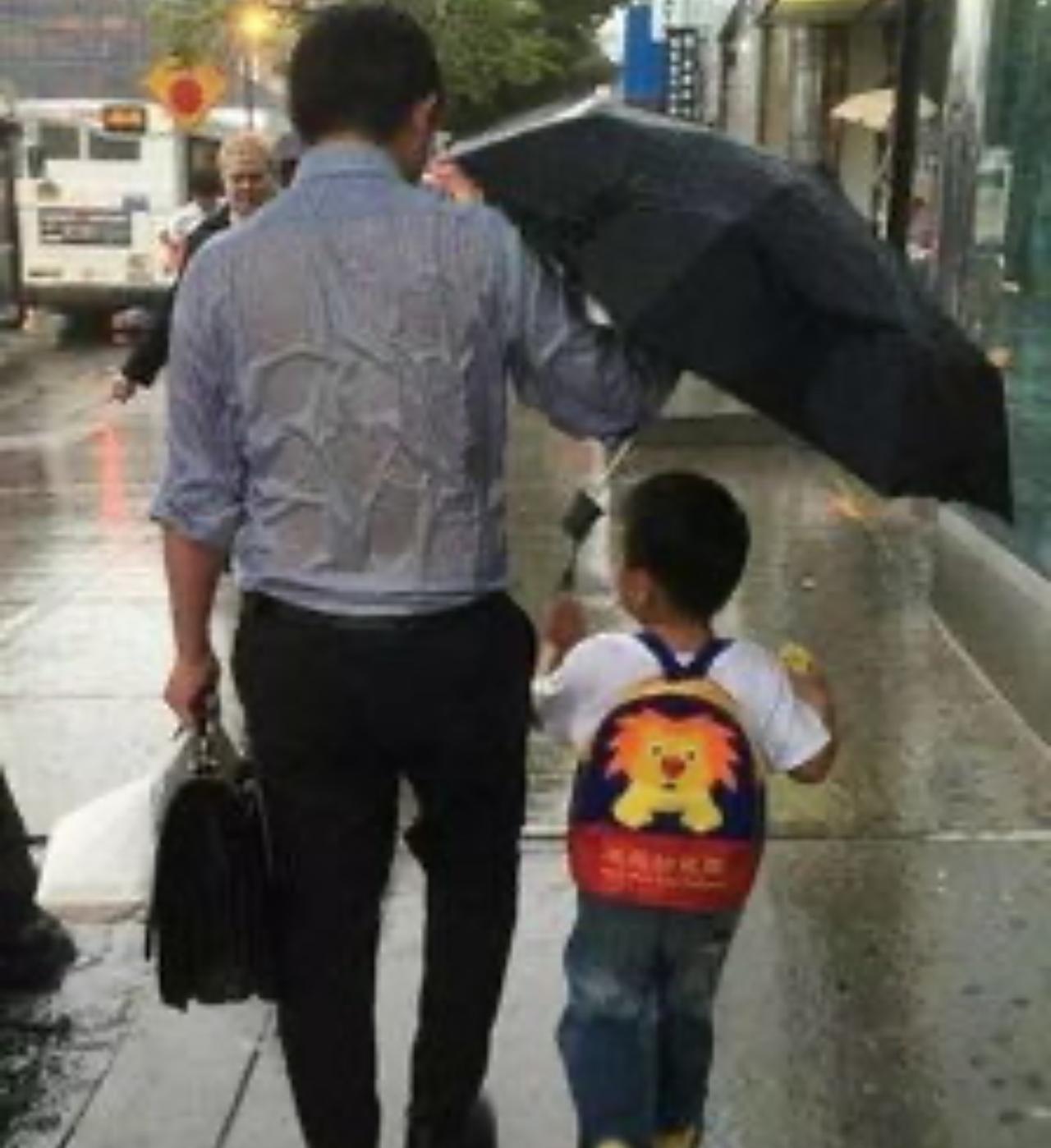 放学时暴雨突至，我踩着水坑往家跑。
拐过街角，忽然发现身后有把蓝伞始终隔着三步距