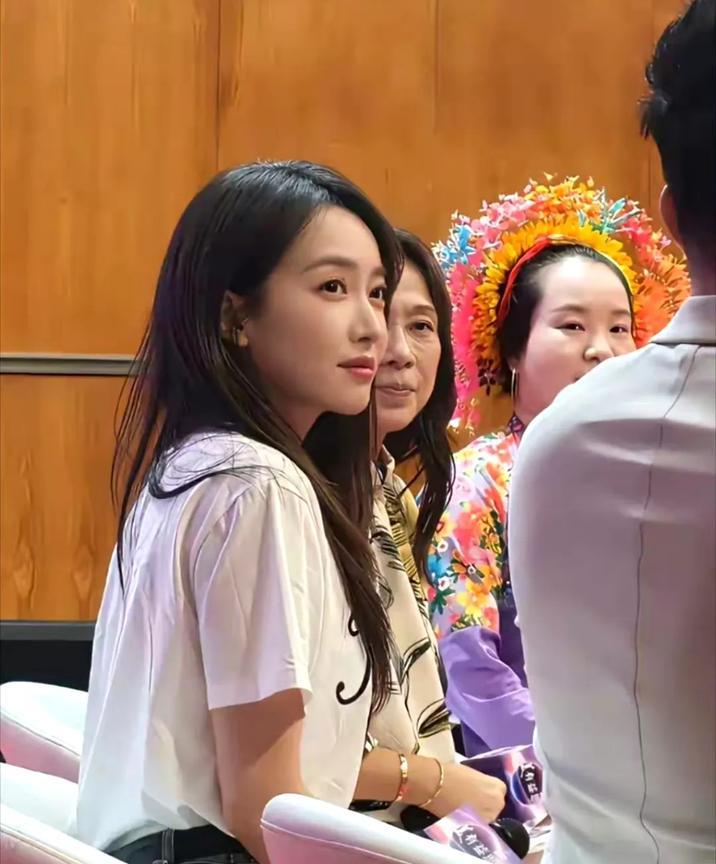 她恬静温婉，花环点缀如自然精灵，浅色服饰与木质背景相融，嘴角浅笑流露岁月静好的温