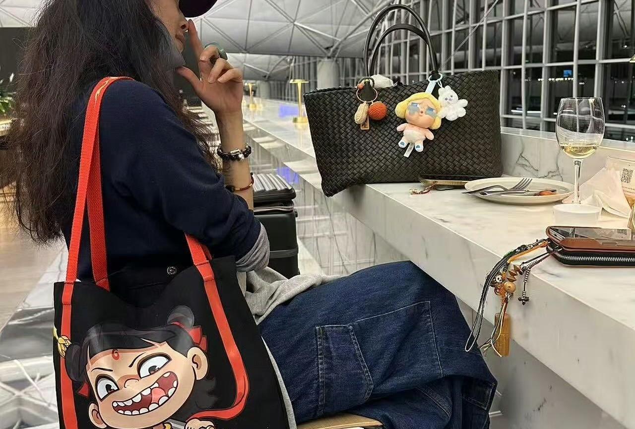 看看舒淇背的帆布包、皮包、钱包、手机链，都是童心未泯的组合，怪不得这么多年过去了
