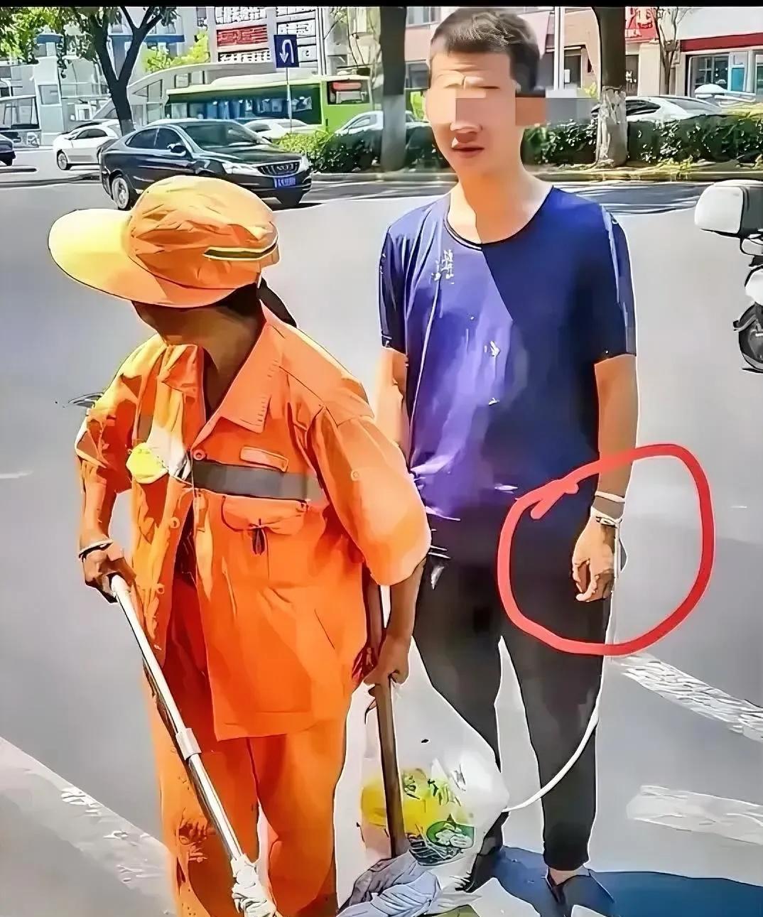 高温40度下，一位环卫工人牵着她30岁、心智有缺陷的儿子，一起在路边清扫垃圾，这