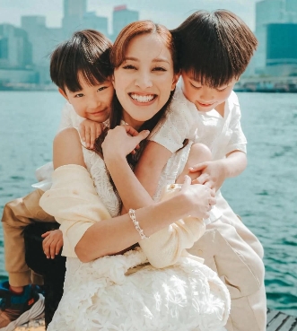 郑嘉颖老婆陈凯琳分享和儿子的海边亲子时光，她身穿一袭白色蕾丝无袖旗袍，搭配针织开