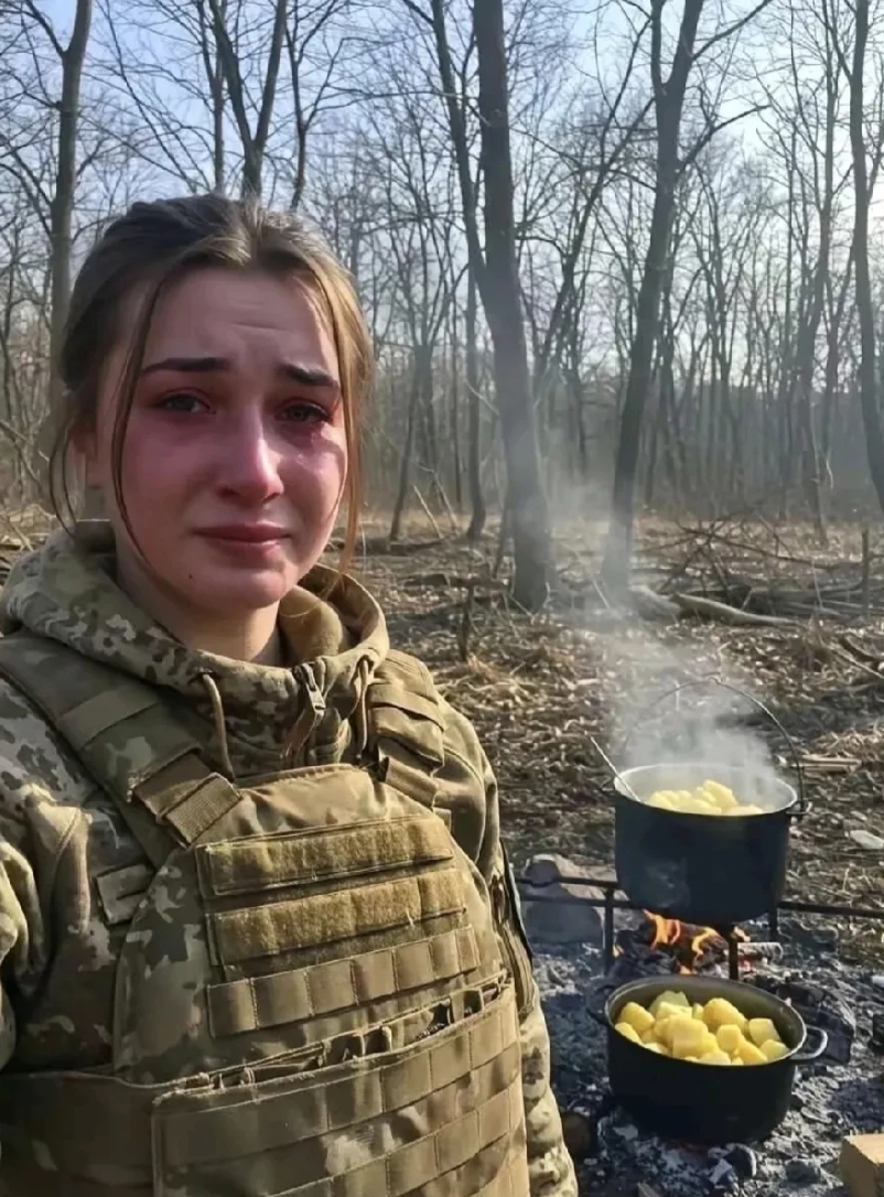 俄乌前线一名乌克兰女兵，自拍了一张照片，照片里地上可以清晰的看到，放着两口正在煮