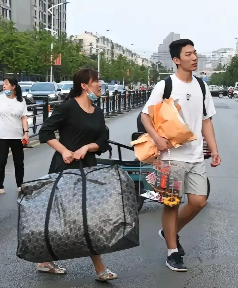 牛高马大的大竟然把最重的包裹留给了母亲，这和桂林挑扁担女孩成了鲜明对比。
有人说