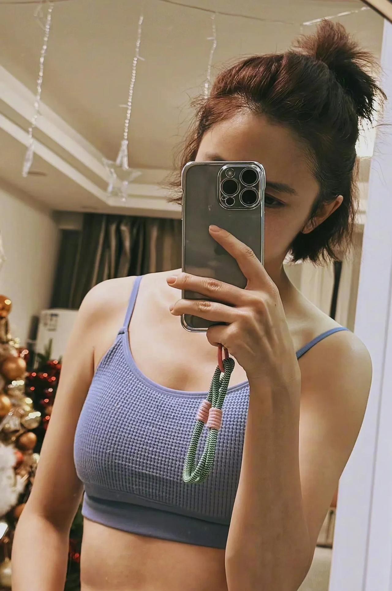 佟丽娅穿浅蓝吊带，对镜自拍，肤光感绝、马甲线炸裂，这身材“杀”疯，美到开挂！