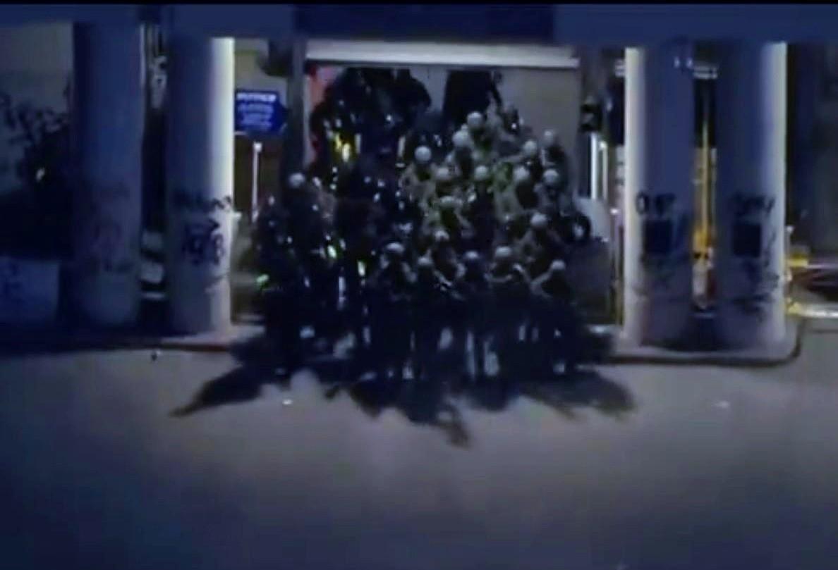 这是一张可以载入历史书的照片。
全副武装的美国国民警卫队队员从一个大门里蜂拥而出