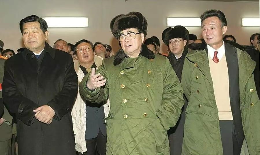 中间穿着军大衣的是李鹏，他担任过国务院总理，全国人大委员长。李鹏身边两位都官至政