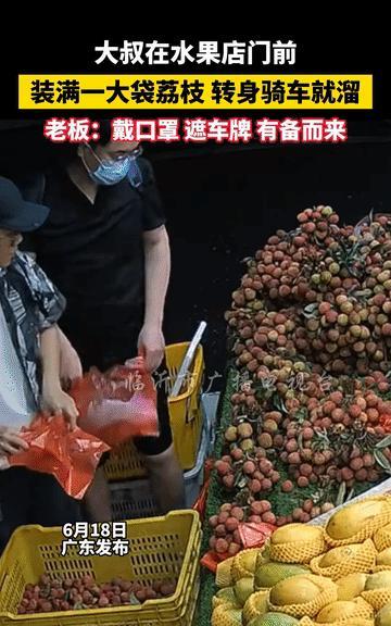 [太阳]6月18日，广东，水果店门口，大叔认真挑选荔枝，很快，大叔就装了满满一袋