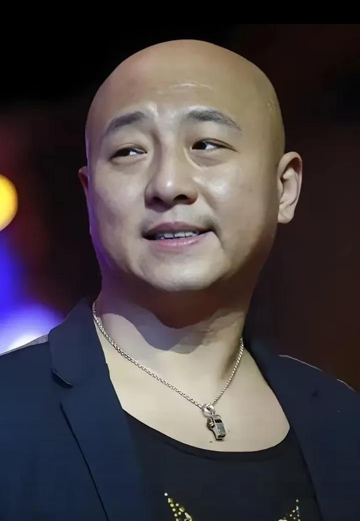 他小眼睛+光头+笑容，说话时咂咂嘴，或者用手指敲桌子这些小动作，都显得特真实，演