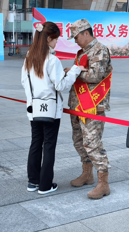 一名女子在火车站亲自送她的男朋友当兵入伍。
两个人站在火车站前面的广场上依依不舍