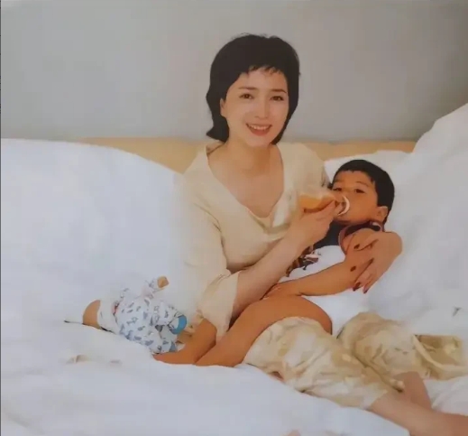 2001年，一张照片定格了何晴初为人母的幸福时刻。画面中，她怀抱着刚出生不久的儿