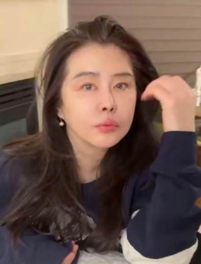 视频中她身着简约家居服，乌黑长发披散，淡妆下眉眼依旧温柔，皮肤白皙紧致，标志性撩