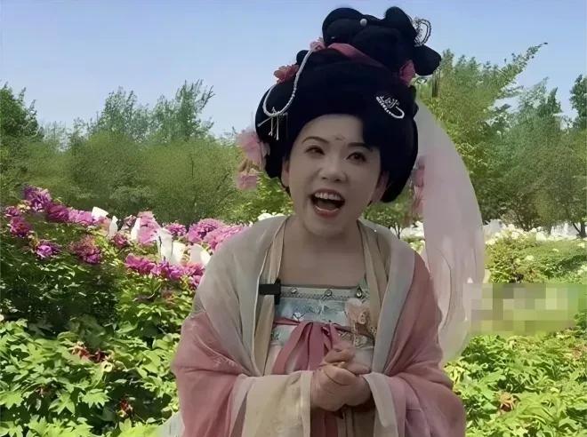 最近，乒坛大魔王邓亚萍现身洛阳牡丹节，一身粉色唐装雍容华贵， 高耸的云髻，眉间漂