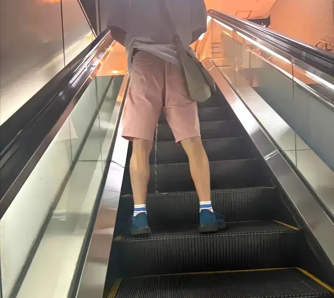凌晨三四点的高铁站电梯口客流有点稀少，可是有一位穿着还算讲究的男子，站在电梯上拉