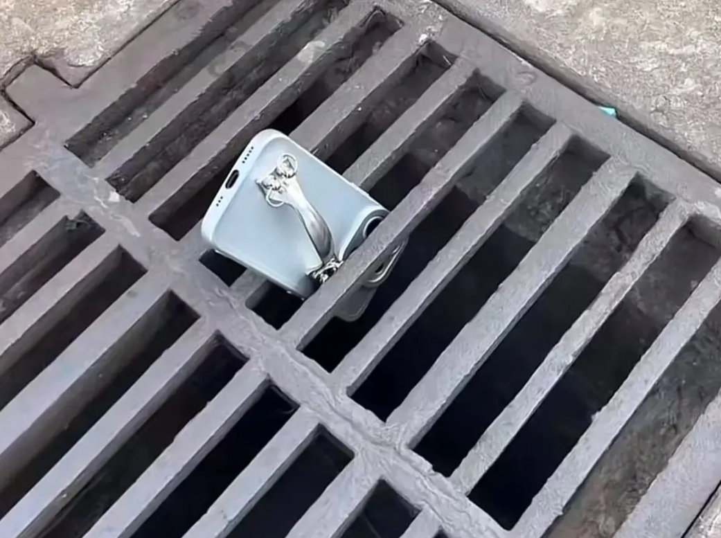 河北，一名男子在下班回家的路，偶然发现路边下水道井盖的缝隙中，卡着一部手机。奇怪
