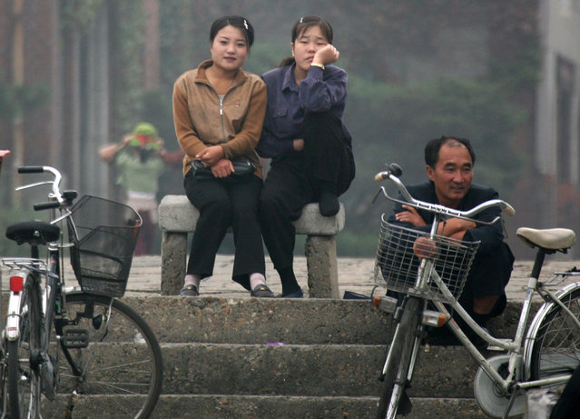 2006 年 10 月 10 日，朝鲜老百姓在朝鲜新义州鸭绿江边观看一艘中国游船