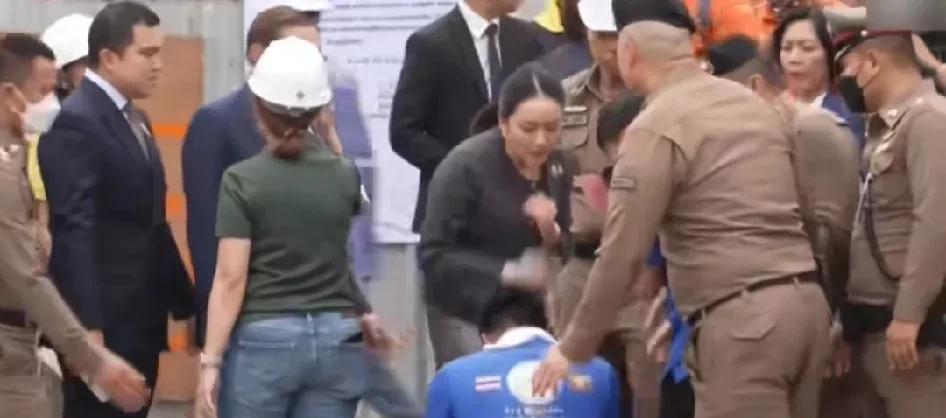 泰国总理佩通坦视察灾区清理工作，与现场的市民交谈，市民跪下表示感谢总理！旁边的随