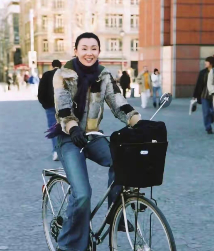 年轻时候的张曼玉骑着自行车，穿搭朴实，颜值在线，是街上一道靓丽的风景线。可惜现在
