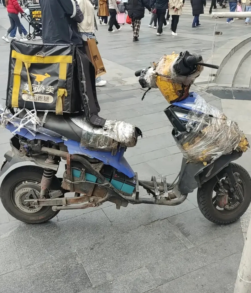 外卖小哥的送餐电动车，从这车的破损程度来看，小哥为了生活，车都已经遍体鳞伤了，每