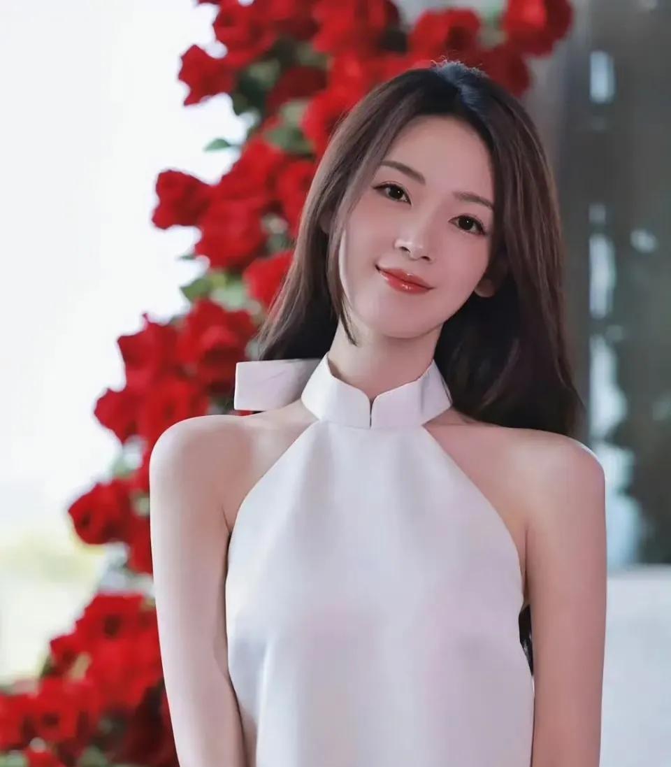 瑶妹的骨相美，好绝  陈瑶 
白色的带花朵小裙裙，加上身后红色的玫瑰花，显得陈瑶