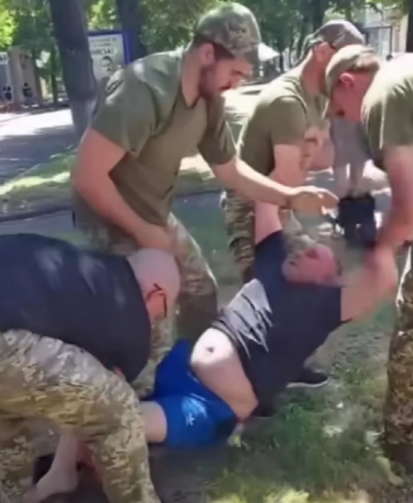又一名乌克兰人被抬走。

这是乌克兰征兵办人员上班的情景，虽然被征人员反抗激烈，