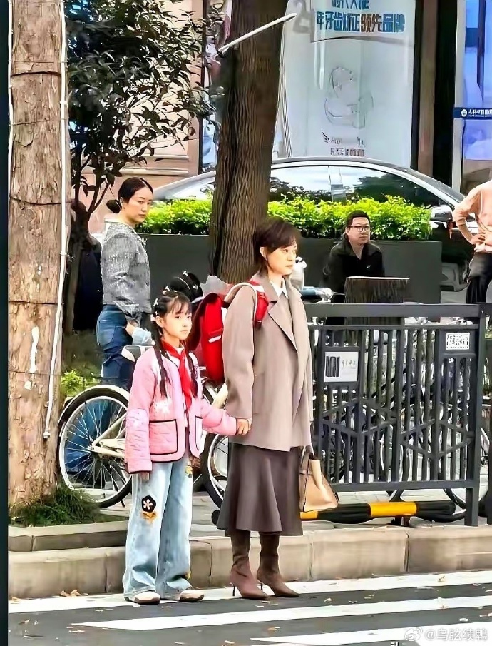 孙俪那个背，真的，我能看一天。
就一张普普通通接女儿放学的街拍，等红绿灯呢，人来
