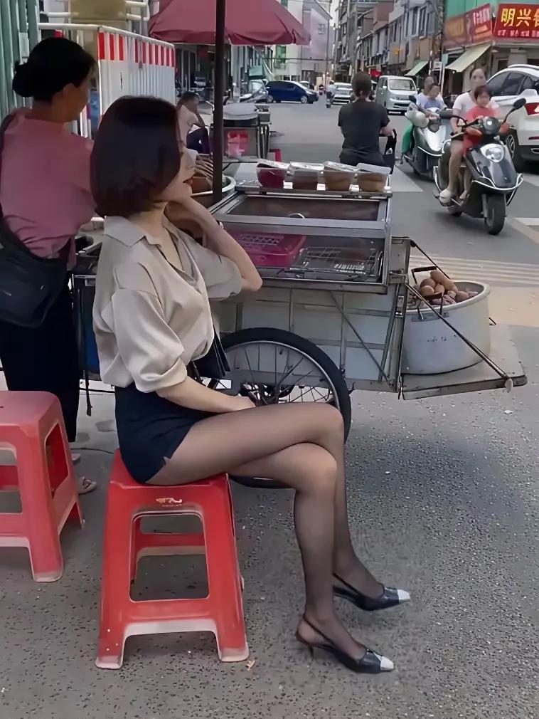 美女在傍边看小吃摊，也是发愁啊，为什么就没有顾客来消费生意呢？
这年头出来摆摊，