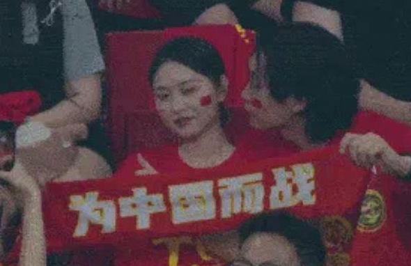 国足比赛看台插曲：男球迷亲女伴遭拒后的傻笑