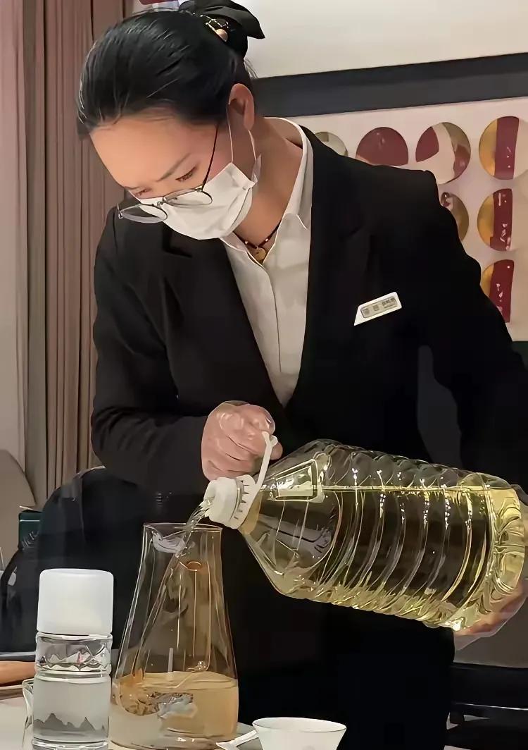 纳闷，他们在饭店里吃饭，怎么看起来服务员给每个人杯子里倒油呢？不让喝白酒，改喝油