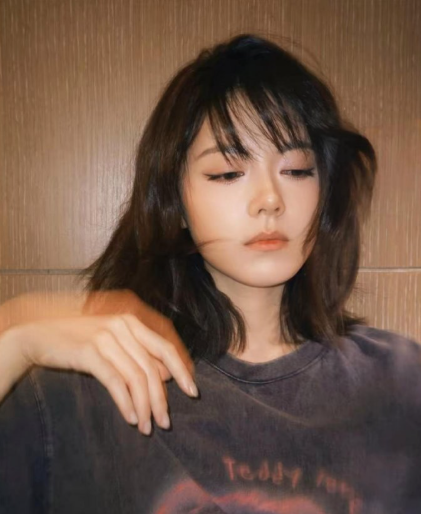 她的娃娃脸自带幼态，可偏偏眼神里总带着点超越年龄的坚定，就像颗裹着糖衣的坚果，甜