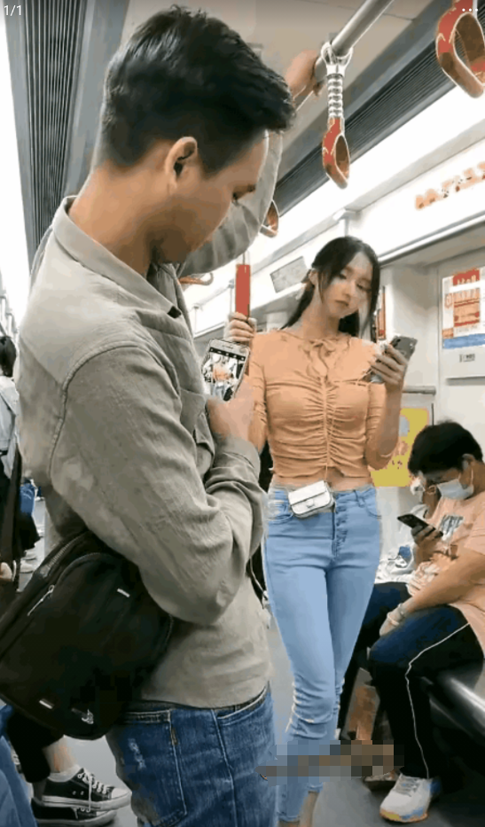 地铁里，一女子站在车厢里，专注的看着手机，这时，一旁的男子被女子深深的吸引住了，
