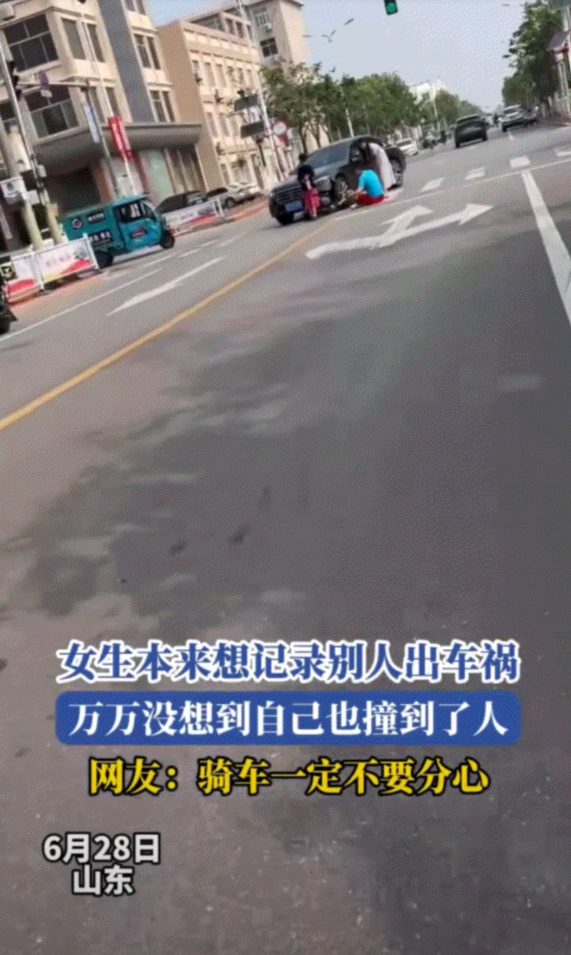 哭笑不得。山东，一女子骑着电动车行驶在路上时，遇到路边的一起车祸，于是女子则拿出