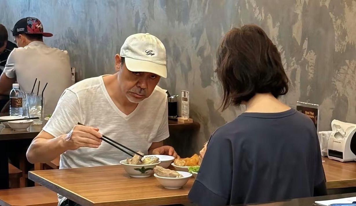 刘青云和老婆郭蔼明在泰国一家餐馆吃饭，看到有民众偷拍，他恶狠狠地瞪着镜头，眼神有