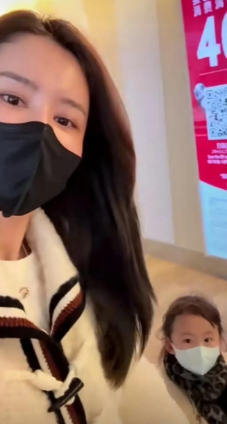 视频中，张馨月穿着绿色的滑雪服，美丽大方，女儿穿着彩色衣服，漂亮可爱，林峯穿着黑