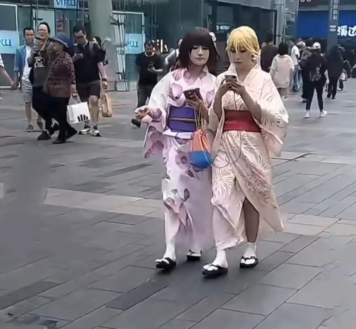 网友在成都的街头上拍到的，两名身穿日本和服，脚踩木履鞋的少女，堂而皇之的走在大街