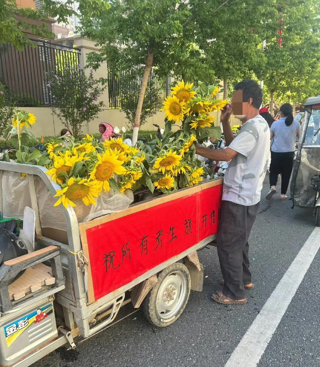 6月21日，河北中考第一天。邯郸市下属县某考点外，一个开着电动三轮车卖向日葵的6