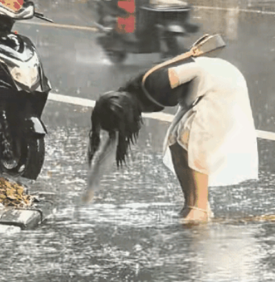 “最美女孩！”大雨中，女孩光着手清理着堵塞下水道的树叶与垃圾。任凭雨水将自己全身