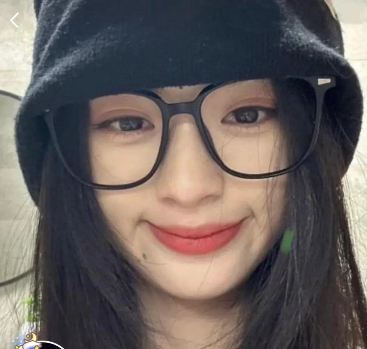 钿姐更换了一张背景图，是张戴帽戴黑框眼镜的近脸照片，抿嘴笑着，红唇弯弯得像艘小船