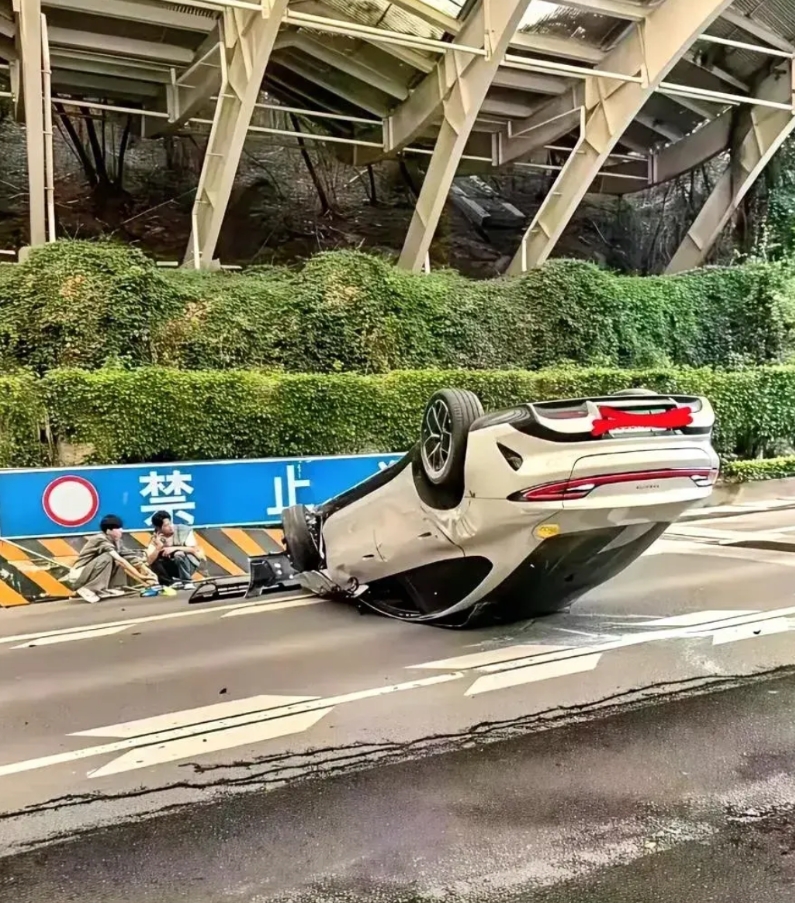 这图真是太有喜感了，后面是“禁止停车”的牌子，前面蹲着两人，和一辆倒扣的公路大马