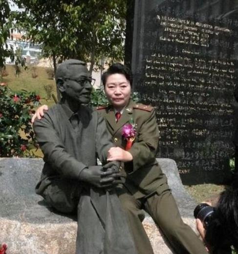1997年，陈景润的夫人坐在丈夫的雕塑旁边，搂住“丈夫”的肩膀，留下了这张令人垂