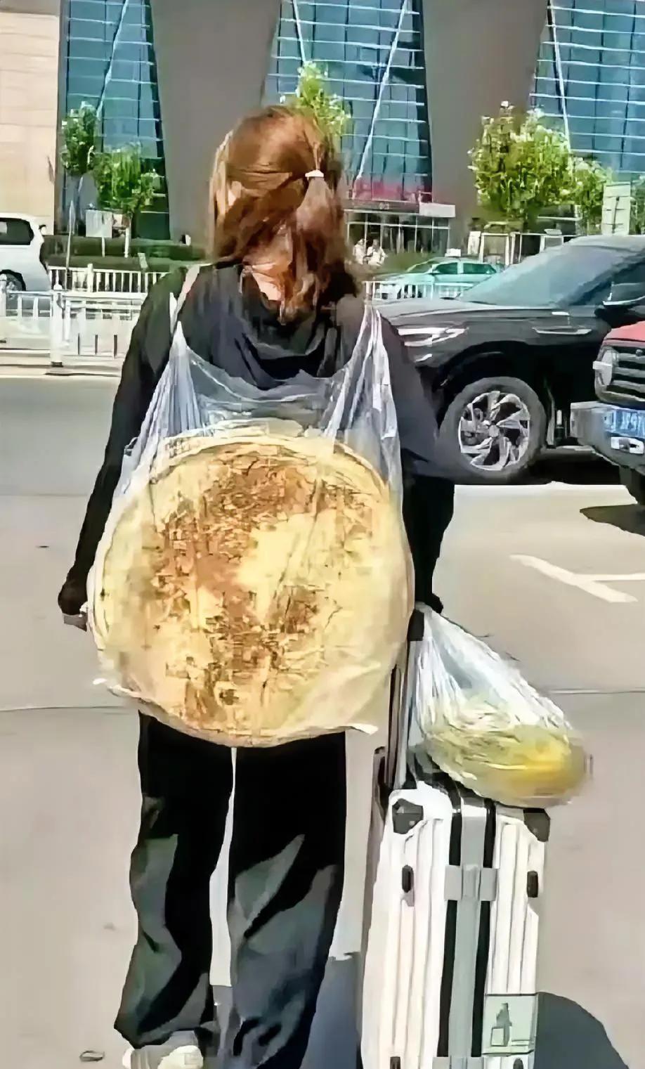 一张新疆女孩背着两个大饼和一个哈密瓜走出机场的照片，火爆全网，网友们议论纷纷！
