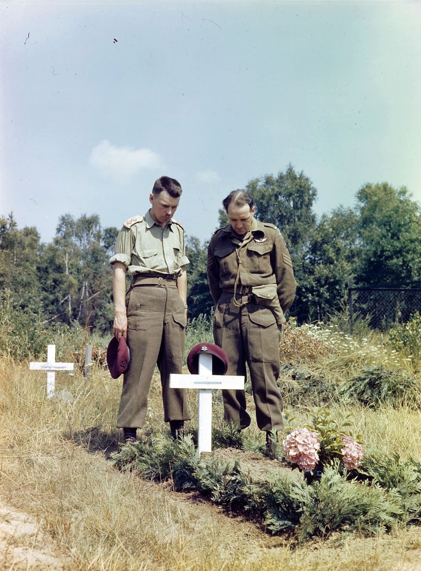 1945 年，加拿大士兵在一位阵亡战友的坟墓前。1945 年，加拿大士兵在一位阵