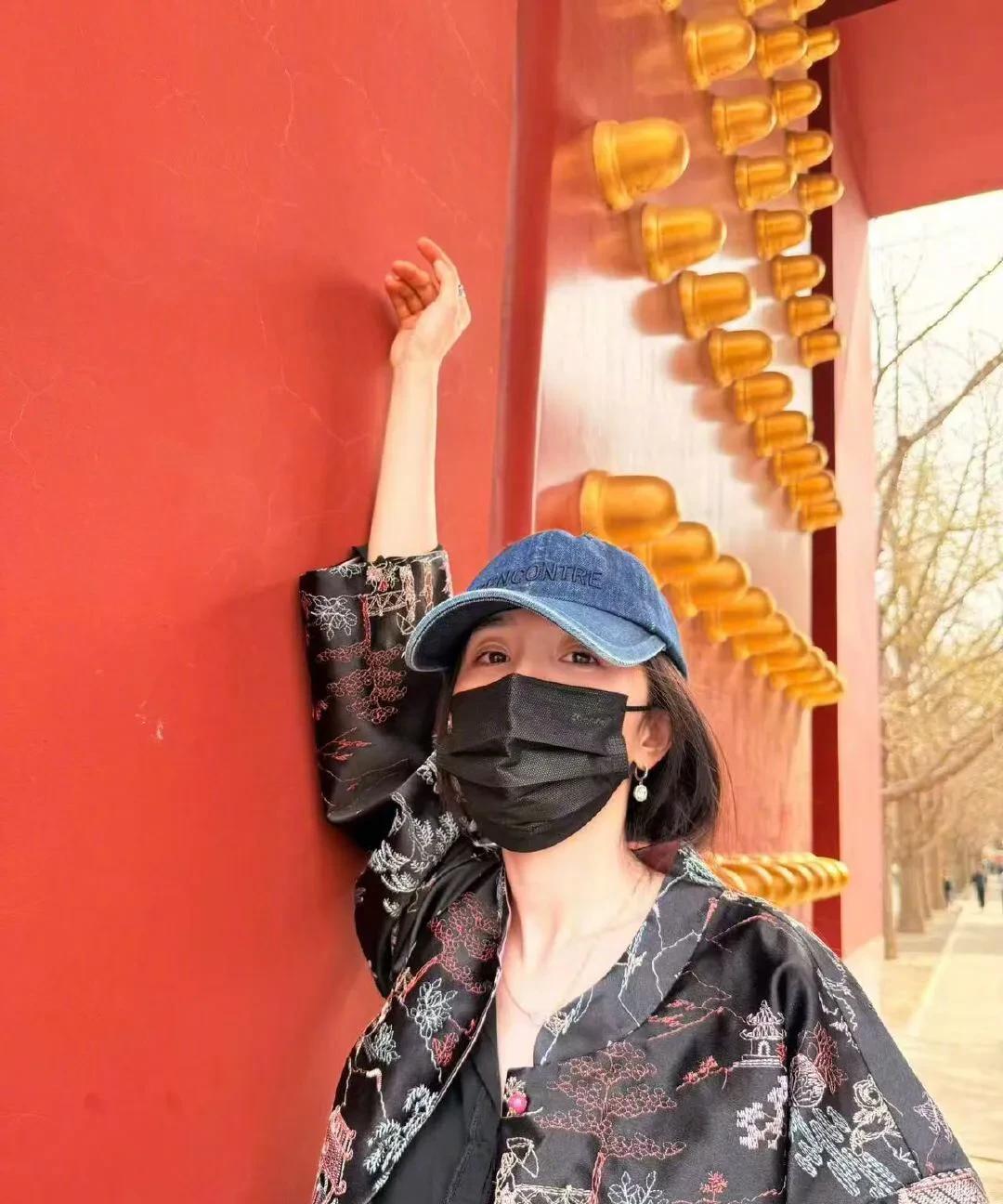 杨幂的出门游玩照，红墙绿瓦外加一点柳叶，环境美丽，杨幂状态也非常松弛自然。