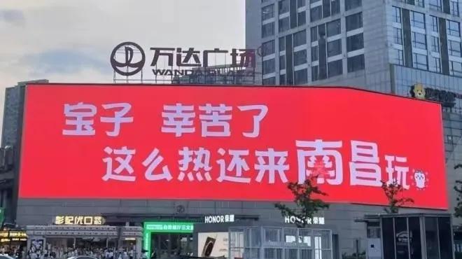 “宝子  幸苦了  这么热还来南昌玩”。这是在南昌市某万达广场的大型显示屏上打出
