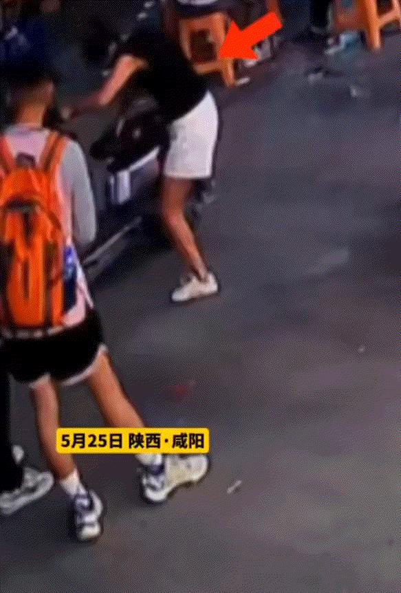 陕西咸阳一街头，一对面戴口罩的男女骑着电动车在街头偷东西，期间二人就看见一抱着娃