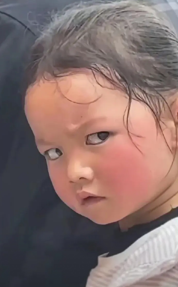 小女孩眼神是把刀！
这小孩子坐在爸爸的电车后座，
与后人对话时被拍了，那一瞬间这